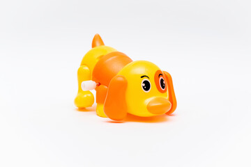 Colorful orange yellow plastic dog wind up toy isolated on white background mockup banner with copy space, toys for children, kids development, playing, childhood fun