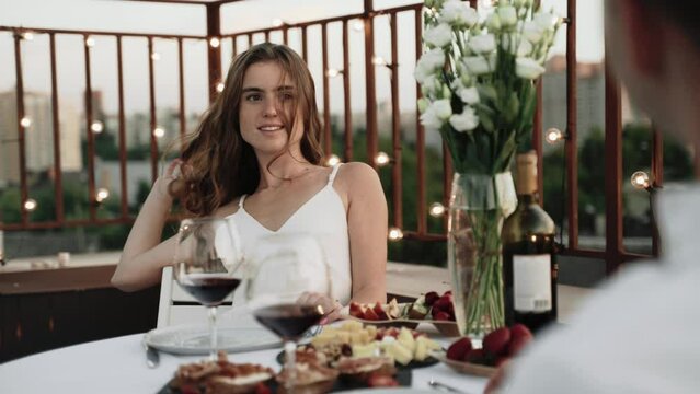  Romantic dinner, woman flirts with a man and twists her hair on a finger