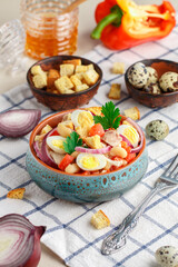 Delicious salad of chicken fillet, bell pepper, white beans, quail eggs, bread croutons, red onion and parsley with a sauce of olive oil, mustard and honey. Selective focus