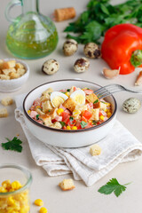 Delicious salad of bell peppers, corn, quail eggs, ham, bread croutons and parsley with olive oil. White plate, linen napkin. Selective focus