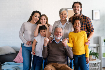 Multi generation, multiethnic family at home together, grandfather with disability