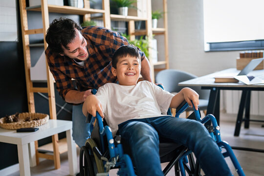 Single Parent With Asian Child With Disability In Wheelchair