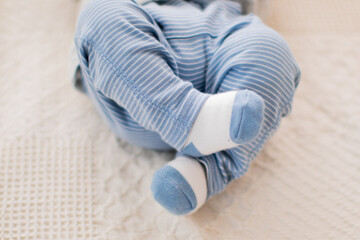 Fototapeta na wymiar Cute Little Baby Boy feet in blue and white socks