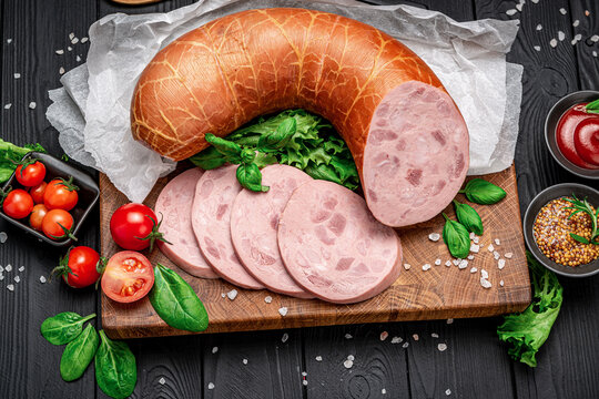 Italian thick boiled sausage on a dark background.