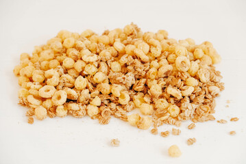 Dry muesli with cornflakes, nuts and raisins on a white background