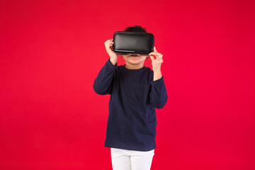 Front view of little girl wearing virtual reality glasses amazed and touching with her hands...
