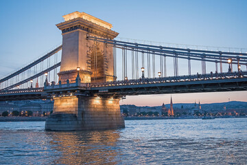 Obraz premium Chain bridge spans the Danube River in Budapest, Hungary at dusk.