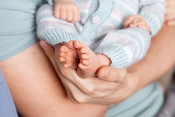 Baby feet in father hands. Tiny Newborn Baby's feet on male Shaped hands closeup. Dad and his Child. Happy Family concept. Beautiful conceptual image of Parenthood