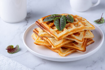 Homemade delicious belgian waffles on the white table. 