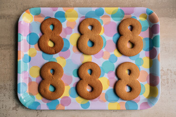 The process of making gingerbread for March 8. Cut out figure eights from dough on a tray. Preparation for baking. Home cooking for the holidays. High quality photo