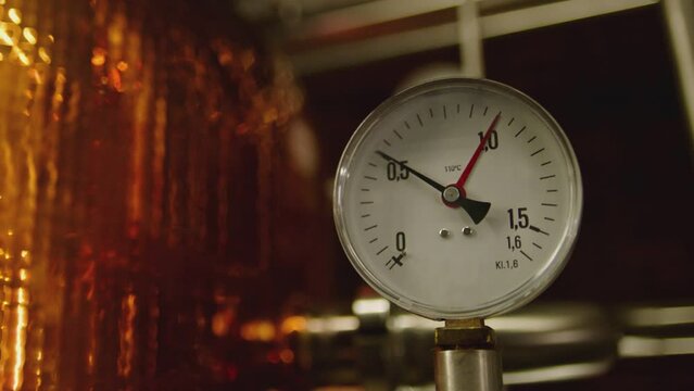 Close up Pressure gauge inside of an alcohol drink factory . Tachometer or manometer with numbers and arrows for vodka or whiskey preparation and distillation  . Measuring the pressure . Slow motion