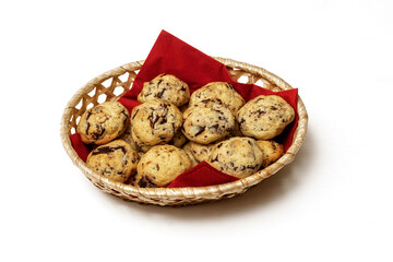 Basket on a white background with a red napkin and delicious homemade cookies stuffed with nuts and chocolate pieces.