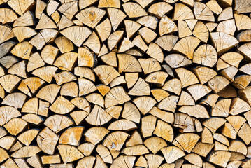 Stacked chopped wood close-up texture. Firewood storage background. Stocks of wooden logs. Chopping wood for a fireplace. Woodpile with firewood with visible wooden texture.