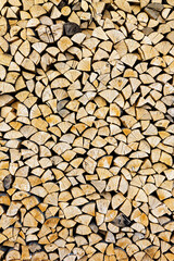 Stacked chopped wood close-up texture. Firewood storage background. Stocks of wooden logs. Chopping wood for a fireplace. Woodpile with firewood with visible wooden texture.