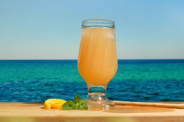 Glass of orange cocktail at beach bar.