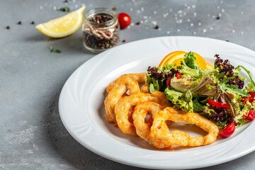fried crispy onion rings served on round black stone tray, american unhealthy calories meal. Delicious pub style, appetizer, restaurant menu, top view