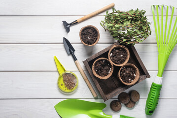 Garden tools, flower pots and gloves on the wooden flat lay table background. Gardening background.