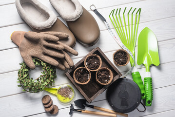 Fototapeta na wymiar Garden tools, flower pots and gloves on the wooden flat lay table background. Gardening background.