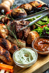 delicious grilled meat with vegetable. Mixed grilled bbq meat with vegetables on wooden platter....