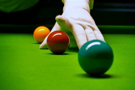 Snooker table and balls with referee arranging the balls