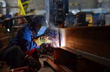 Fototapeta na wymiar A welder works at a factory 