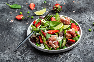 Healthy salad. green asparagus, strawberry, rocket and cottage cheese. Healthy balanced eating. Top view