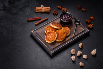 Cottage cheese pancakes, syrniki, ricotta fritters on a wooden cutting board