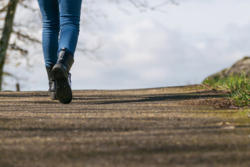 legs of a woman walking down a country road.