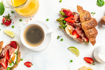 Delicious fresh breakfast served grilled bun with spinach and cheese, asparagus, jamon, ham,...