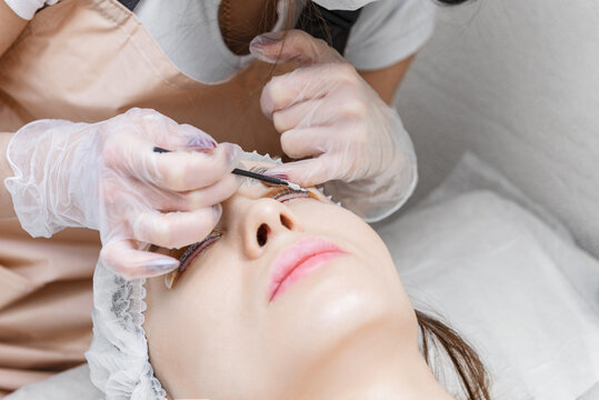 Eyelash procedure with clinic master and a client in a beauty salon