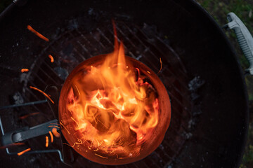 Looking down into the burning charcoal of a Chimney Starter on a backyard grill
