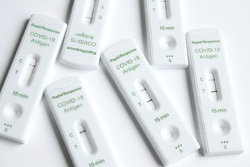 Positive and negative Covid-19 coronavirus rapid response antigen tests in white plastic boxes on...
