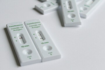 Positive and negative Covid-19 coronavirus rapid response antigen tests in white plastic boxes on...
