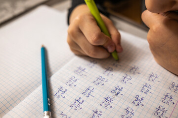 Mathematical examples that the student writes and solves. Sum and subtraction. Algebra. Pen and pencil on a checkered notebook. High quality photo