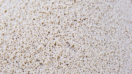 Secondary granule made of polypropylene, white Plastic pellets crumbles to the table. Plastic raw materials in granules for industry. Polymer resin. Raw plastic recycling concept