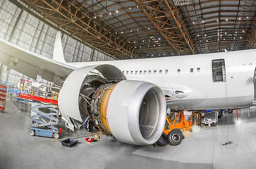 Passenger aircraft on maintenance of engine and fuselage repair in airport hangar. View airplane engine. © aapsky