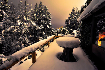 paisaje de un balcon con mesa y baranda en una noche de nieve en bariloche argentina
