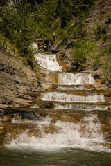 Obraz premium Small waterfalls through a rocky canyon in the Crowsnest Mountain pass