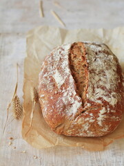 A loaf of bread and a bowl of wheat on the table