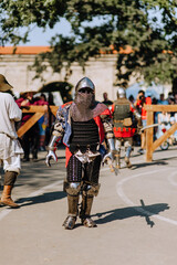 A strong knight, a warrior stands, walks across the battlefield after a victory, guarding the state...