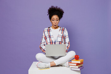 Full body shocked young girl woman of African American ethnicity teen student in shirt hold use...