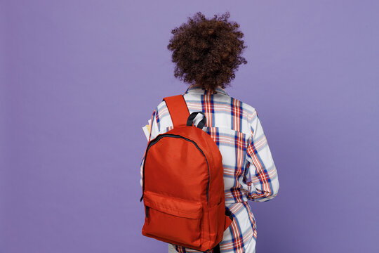 Back Rear View Of Young Girl Woman Of African American Ethnicity Teen Student In Shirt Backpack Isolated On Pastel Plain Purple Color Background. Education In High School University College Concept.