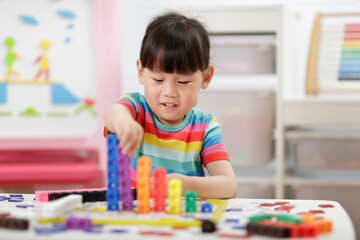 young girl play number blocks for homeschooling