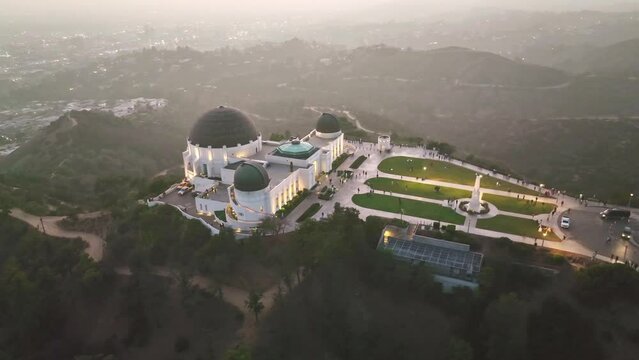 Aerial drone view of Griffith Park observatory, Los Angeles night skyline. California landmark, travel destination in America.