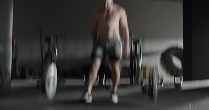 Muscular sportsman doing snatch exercise with barbell
