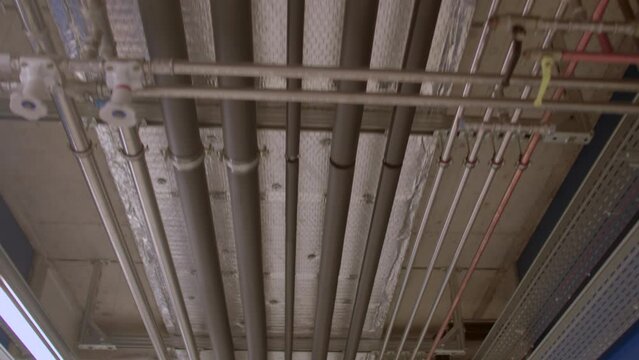 Many pipes are attached to the ceiling. Transportation of resources using pipes. Engineering solution.
