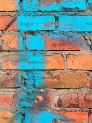 old brick wall painted with turquoise spray paint