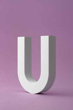 Vertical Shot Of U Letter Shape Object On Purple Background With Copy Space