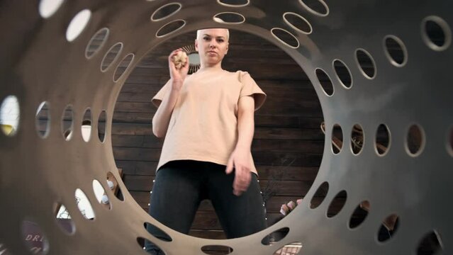 young blond woman with short haircut walks to trash can and throw crumpled piece of paper into it. View from inside trash can, piece of paper fall into basket. concept of ecology and garbage sorting