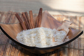 Wooden bowl with salts and cinnamon in an outdoor spa